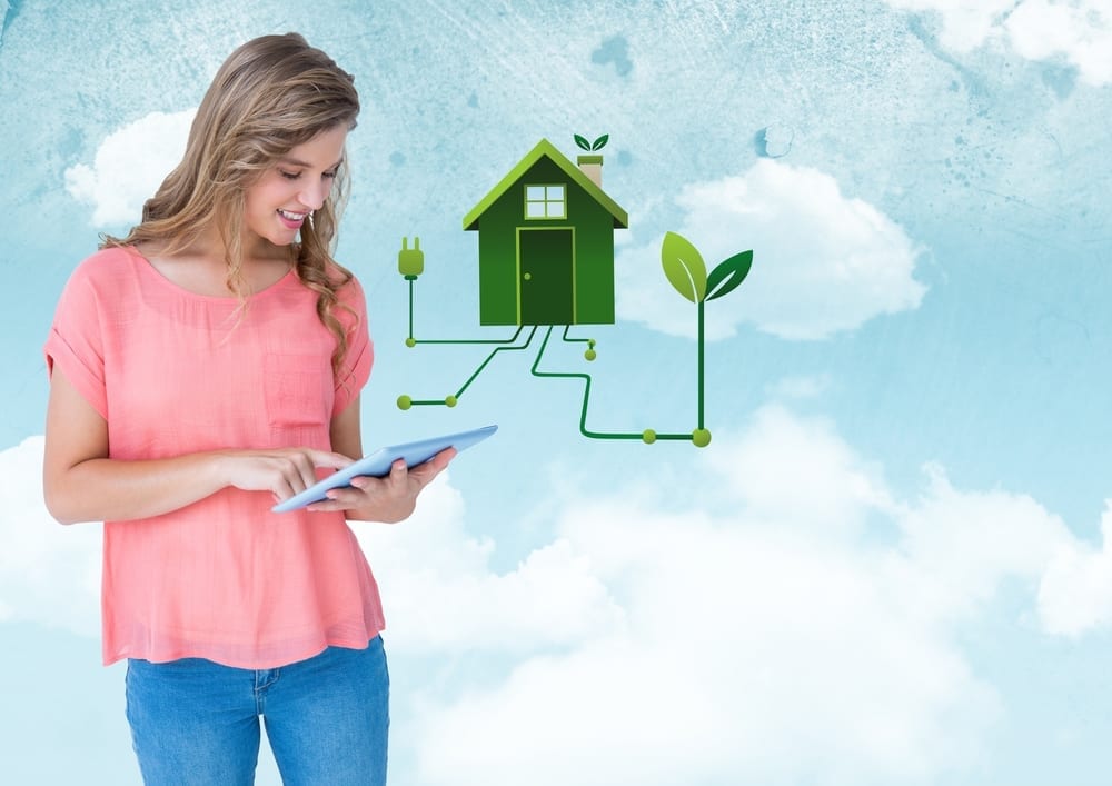Digital composite of Woman with tablet and green house graphic against sky
